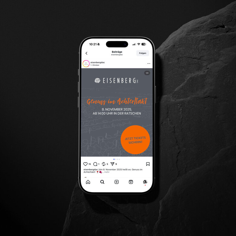Smartphone-Mockup mit einem Instagram-Posting des Eisenberg DAC. Zu sehen ist eine Grafik mit dem Text: „Eisenberg DAC – Genuss im Achterlakt. 8. November 2025, ab 14:00 Uhr in der Ratschen“. Darunter ein orangefarbener Kreis mit der Aufschrift „Jetzt Tickets sichern!“. Das Design ist in Grau und Orange gehalten.